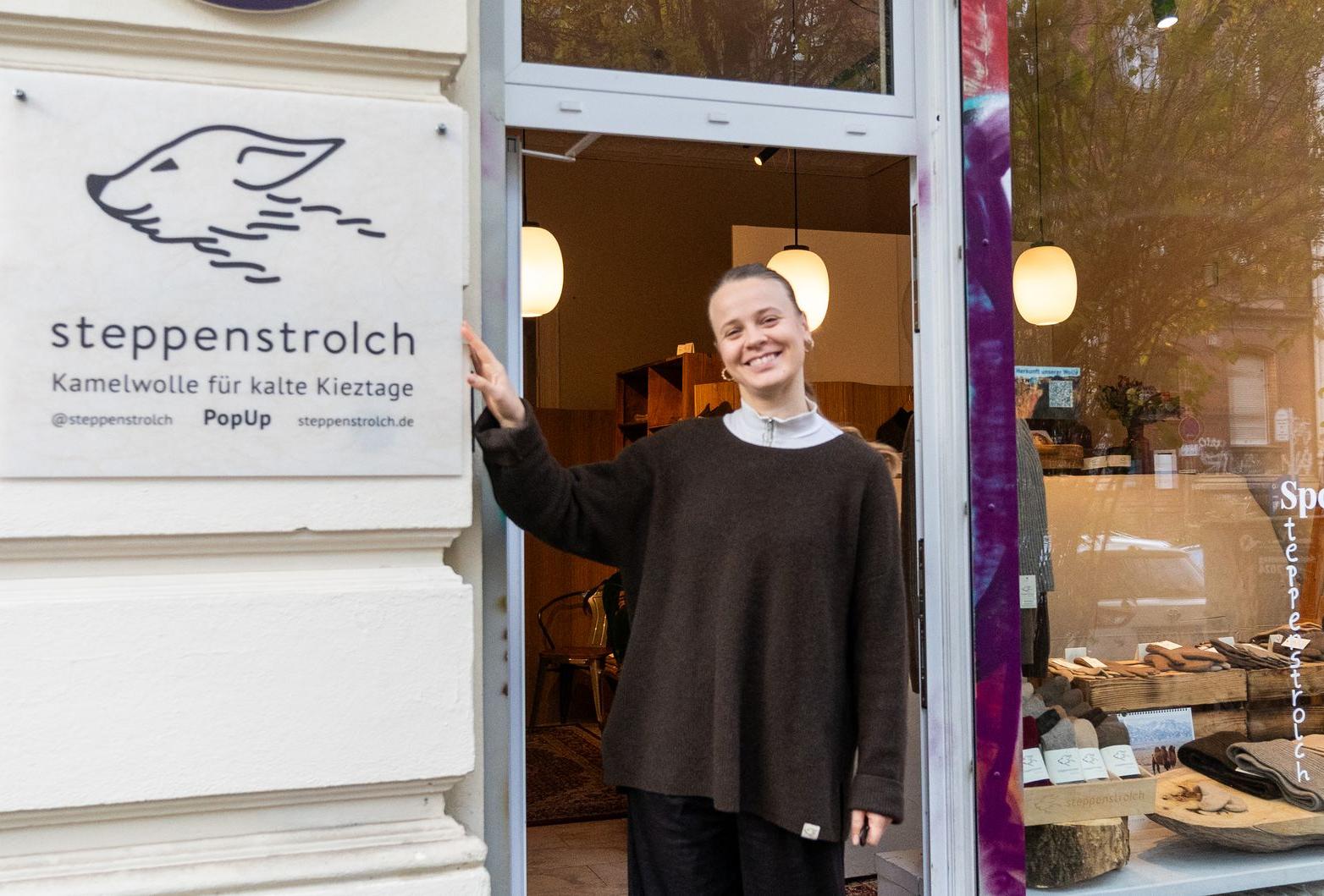 Eszter leitet unseren Laden in Berlin bis Februar Eine Frau vor einem Ladengeschäft mit steppenstrolch Logo